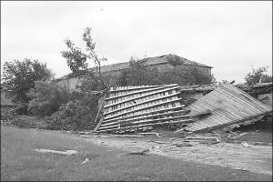 Поруйнований 11 червня ураганом дах будинку в райцентрі Любешів Волинської області. Поряд лежать кілька зламаних буревієм дерев