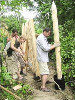 Рабочий из Закарпатья Иван Мигалко осмаливает столб. Строят настоящий казацкий частокол, чтобы дети-отдыхающие смогли представить себя защитниками Украины