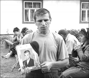 Михаил Трохимчук держит портрет погибшего сына Вадима. Пуля попала парню в голову