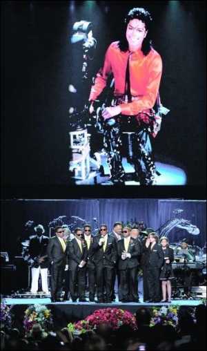Семья Майкла Джексона прощается с певцом в спортивно-развлекательном ”Степлс Центре” в Лос-Анджелесе. Вверху на большом экране показывают фотографии короля поп-музыки и отрывки из его клипов