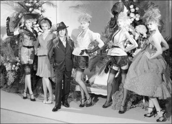 Джона Гальяно на колекцію для модного дому ”Крістіан Діор” надихали жіночі образи 1950-х: підфарбовані червоною помадою губи, високі підбори, підкреслена талія