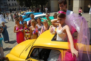 Анна Пенцак і Тарас Дончура фотографуються у ”горбатому ”запорожці” в день свого весілля на площі Ринок у Львові