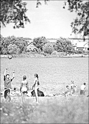 Отдыхающие загорают и купаются на пляже возле озера Задорожнее близ села Демня Николаевского района. На противоположный берег их не пускают охранники дачников