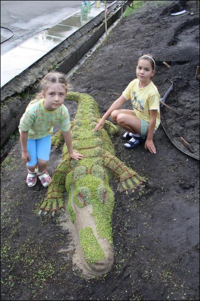 Киянки Валя Стефанова і Соня Соловйова біля 1,5-метрового крокодила з моху. Бабусі привели їх погратися на спортивний майданчик неподалік квітів-скульптур