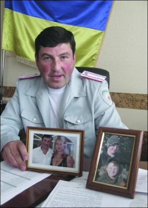 Начальник Державтоінспекції Вінниччини Геннадій Прокопович показує світлини своєї родини, які стоять на столі у нього в кабінеті