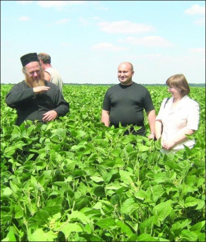 Фермер Алексей Дон (крайний слева) показывает сою, которая растет на его поле в селе Иванов Теплицкого района. Он выращивает ее без химических удобрений