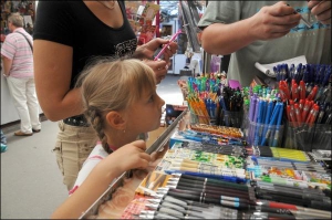Дівчинка вибирає у середу по обіді кулькову ручку на столич-ному книжко-вому ринку Петрівка