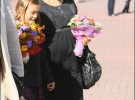 Вагітна Віталіна Ющенко з букетом осінніх квітів веде у ліцей доньку Ярину-Домініку