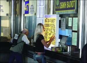 Кассир обменника банка ”Золотые ворота”, что на Южном железнодорожном вокзале в Киеве, изменяет курс доллара. За день он подешевел здесь на 8 копеек