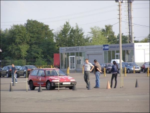 Водитель-охранник главы ”Регионов” Виктора Януковича Владимир (слева) общается со своим инструктором Алексеем Пилипенко 8 сентября 2009 года. На этой красной  ”хонде” он отрабатывал ”полицейский разворот” и посбивал конусы