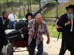 Михайло Воєводін везе валізи прочан на гору, вулицею Визволителів в Умані. За 300 метрів бере плату 6 доларів