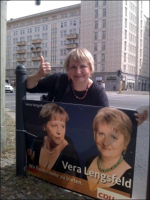 Депутатка від ”Християнсько-демократичного союзу” із Берліна Віра Ленґсфельд біля свого передвиборного плаката. На ньому вона та канцлерка Ангела Меркель у сукнях із глибоким декольте. І напис: ”Ми можемо запропонувати більше”