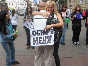 Киевлянка Настя Гайдак обнимает прохожего возле станции метро Арсенальная. В Киеве она проводит акцию "Обними меня"