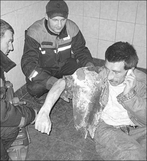 Вячеслав Ильминский с выбитым спасателями унитазом на руке разговаривает по мобильнику. На вокзале говорят, за поврежденную туалетную кабинку будет платить Ильминский. Ремонт обойдется в 600 гривен
