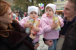 Подружжя львів’ян Марта і Дмитро Менцінські тримають у суботу доньок-близнят Дзвінку і Дарію на ярмарку органічних продуктів на площі Ринок у Львові. Дівчатка їдять пшеничні хлібці ”Хрумтик” з екологічно чистого зерна, вирощеного на Харківщині