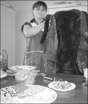 Світлана Карп у ресторані ”Лемківський хутір” у селі Великі Ходачки на Тернопільщині показує традиційний лемківський одяг. На столі – салат ”Веселка” і мариновані грибочки