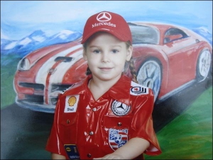 Жительница Донецка Инна Цвилева фотографируется в школе на фоне плаката со спортивным автомобилем. Девочку одели в форму пилота команды ”Мерседес”