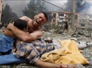 Грузинский мужчина плачет, держа тело своего родственника, после бомбардировки в Гори,  80 километров от Тбилиси, 9 августа 2008 года. Российский военный самолет сбросил бомбу на жилой дом в Гори в субботу, убив по меньшей мере 5 человек. Бомба попала в п