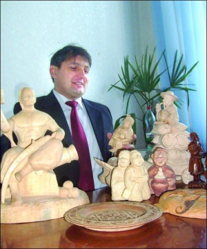 Заступник селищного голови Чорнобая Володимир Огнівенко у своєму робочому кабінеті демонструє вирізані власноруч дерев’яні фігурки