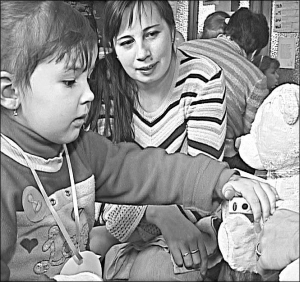 Пятилетняя Марина Завада измеряет давление плюшевому мишке в игровой комнате областной больницы Ивано-Франковска. Рядом с ней ее мама Оксана