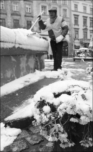 Львов, 14 октября 2009 года, центр города. Работник муниципальной службы убирает лопатой первый снег