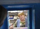Продавщица Антонина Ущенко отпускает заключенным товар через окошко. Она является работницей колонии
