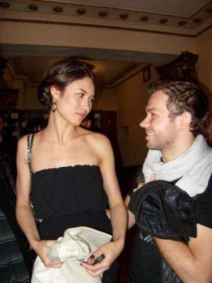 Французская актриса Ольга Куриленко разговаривает с дизайнером Андре Таном. На презентацию своего фильма ”Стены” она надела черное платье от этого дизайнера