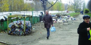По обе стороны тротуара на улице Громова в Черкассах лежат горы мусора. Его не вывозят уже месяц