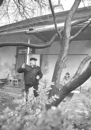 Игорь Гомоль (слева) стоит перед домом в ботаническом саду Львовского университета имени Франко на улице Кирилла и Мефодия. Перед крыльцом растут магнолии и алыча