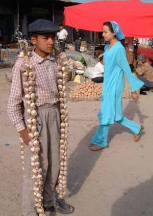 Подросток продает чеснок на улице города Ош в Киргизии. Там неурожай лука и чеснока. Цена выросла вдвое — до 15 сомов за кило. Это 2,9 гривны. Картошку продают по 9 сомов. Киргизы в среднем зарабатывают 4,5 тысячи сомов, это 826 гривен
