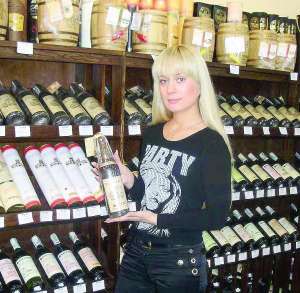 Продавець — консультант відділу вин магазину ”Делікат” Анна Тернова показує найдорожче вино, яке можна придбати в Черкасах — Мускат Білий  урожаю 1929 року 