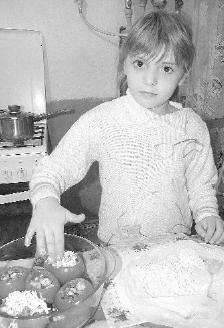 Винничанка Диана Мовенко, 7 лет, помогает матери фаршировать помидоры. Внутрь напихает куриное филе, посыпает сыром