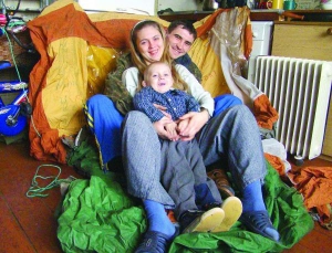 Юрий Жук, Кристина Есейкина и их трехлетний сын Юрий в комнате общежития во Владимире-Волынском. Сидят на палатке с революционного Майдана