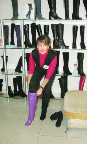 Продавець вінницького магазину ”Раса” Марина Воркіна приміряє модні чоботи бузкового кольору на каучуковій підошві за 1100 гривень