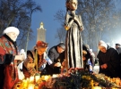 Киевляне кладут к подножию памятника жертвам Голодомора свечи и колосья, перемотанные черными лентами