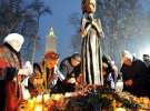 Кияни кладуть до підніжжя пам’ятника жертвам Голодомору свічки та колосся, перемотане чорними стрічками