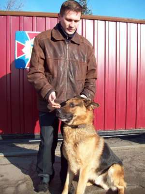 Анатолий Галичев из милицейского спецподразделения ”Ягуар” гладит своего пса Ника, который выследил насильника. Насильник испугался собаки