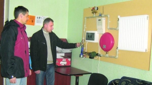 Директор предприятия ”Св-Энерджи” Александр Шимчук показывает посетителю образец отапливаемой системы с электродным котлом