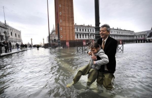 Житель Венеции с дочкой в центре города. Оба в высоких резиновых сапогах — вода в городе достигла отметки 1,3 метра
