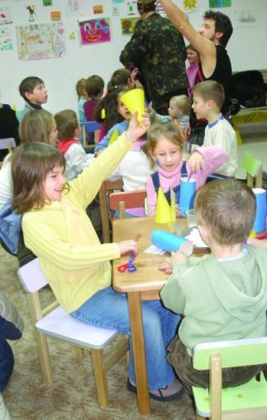 У дитячій ігровій кімнаті ”Магіцентру” 5-річні Олександра Подолян (ліворуч) та Катерина Швець роблять паперових Дідів Морозів. За кілька днів усі поробки дітей повісять на ялинку у ”Магіцентрі”