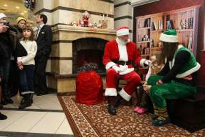 Санта Клаус вместе с помощницей-эльфом расспрашивают девочку о ее желании на первом этаже столичного универмага ”Украина”. Фото сделано в воскресенье
