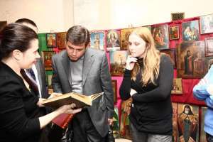 Нардепу-”регионалу” Валерию Бондику предлагают купить старинную книгу на антикварной ярмарке, которую открыли на первом этаже Верховной Рады во вторник