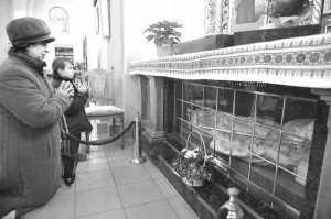 Ганна і Роман Юркевичі моляться біля мощів Миколи Чарнецького у храмі святого Йосафата на вулиці Замарстинівській у Львові