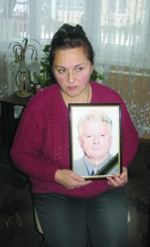 Вдова Татьяна Бакун держит фотографию убитого мужа Николая