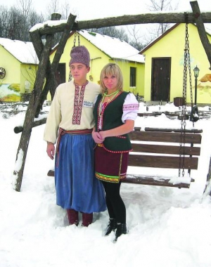 Офіціанти уманського ”Шинку на околиці” Юля Середа та Олег Кривонос чекають гостей у дворі, щоб провести до будинків відпочинку (позаду)