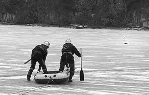 Рятувальники з пожежної частини №4 Вінниці гумовим човном біля Київського мосту рятують лебедя, що примерз до льоду на річці Південний Буг