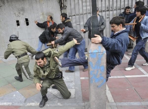 Иранские демонстранты нападают на полицейских 27 декабря в столице Тегеране. С тротуаров отдирали плитку, ею бросали в стражей порядка