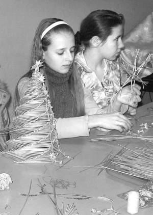 Яна Онойченко і Аня Дехтярчук в Уманському будинку дитячої творчості роблять ялинкові прикраси. Солому перед плетінням замочують у воді