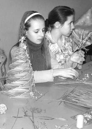 Яна Онойченко і Аня Дехтярчук в Уманському будинку дитячої творчості роблять ялинкові прикраси. Солому перед плетінням замочують у воді