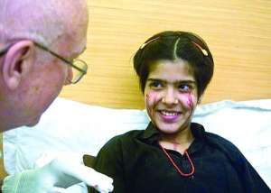 14-летнюю Твинкл Виведи (справа) в больнице индийского города Мумбаи осматривает американский врач Джордж Бушенен. Медики не могут объяснить, почему из глаз и тела девушки течет кровь